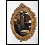 A vintage gilt surround oval wall mirror having an