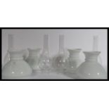 A set of four vintage oil lamp shades and flumes o