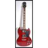 A vintage Gibson electric Epiphone six string guitar having a shaped red body with black scratch