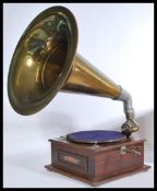 A 20th Century oak cased table top gramophone with brass sound horn and a selection of records.
