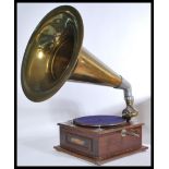 A 20th Century oak cased table top gramophone with brass sound horn and a selection of records.