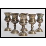 A set of six sterling silver Israeli Kiddush cup goblets raised on circular vases with embossed rose