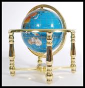 A Lapis Lazuli desk top globe set with precious stone having gilt brass legs with compass to lower