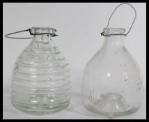 A pair of early 20th Century pressed glass wasp / fly catchers, one of bee hive form and the other