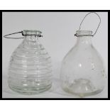 A pair of early 20th Century pressed glass wasp / fly catchers, one of bee hive form and the other