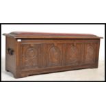 A Jacobean revival oak coffer chest having carved fielded panels to the front, raised on stile