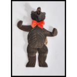 A 20th century carved blackforest articulated dancing bear with glass eyes having moving arm and