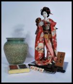 A Japanese Geisha doll with elaborate clothing and