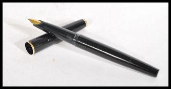 A vintage Mont Blanc fountain pen having black body with white star to lid and end. Gilt metal