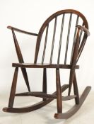 A mid 20th century Ercol rocking chair in beech and elm raised on turned legs with sleigh runners.