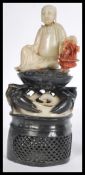 An early 20th century Chinese carved soapstone figurine of a deity holding a vase of flowers