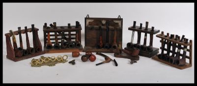 A large collection of early 20th century pipes contained on seven pipe racks to include Peterson