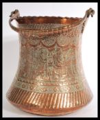 A Persian Safavid large copper bucket with large shaped  handle and deeply engraved foliate