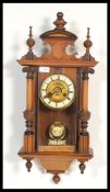A 19th century Victorian walnut wall clock having turned finials with classical columns and arched