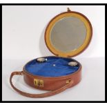 A vintage early 20th century round leather bag having fitted interior with two glass and silver