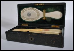 A 19th century Victorian leather cased set of ivory clothes brushes and a mirror, exquisitely carved