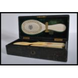 A 19th century Victorian leather cased set of ivory clothes brushes and a mirror, exquisitely carved