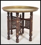 An early 20th century asiatic - anglo colonial folding Binares brass opium table. The base of