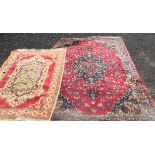 A pair of non matching vintage 20th Century floor rugs, the larger on red ground with central