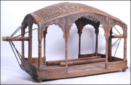 An Indian hardwood and brass embellished palanquin - sedan. The lattice worked domed top over