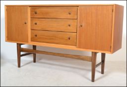 Gordon Russell Of Broadway - A walnut sideboard credenza being raised on tapering legs with a wide