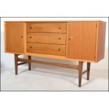 Gordon Russell Of Broadway - A walnut sideboard credenza being raised on tapering legs with a wide