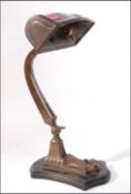 A 1930's Art Deco bronzed brass desk lamp having shaped arm with cylindrical wide pendant shade. All
