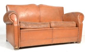 A 1930's French Art Deco Moustache back club settee / sofa in brown distressed leather being