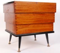 A vintage mid century teak wood beehive shaped workbox - sewing box being raised on turned and