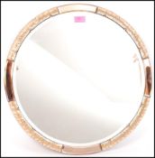 Atsonea - A 1930's Art deco vintage round wall mirror having a peach glass and a bronzed plaster