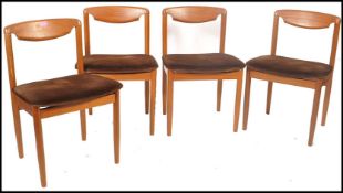 A set of 1970's retro vintage teak wood dining chair having a solid shaped backrest all raised on