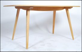 Ercol - An excellent 20th century beech and elm wood refectory plank dining table being raised on