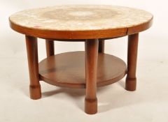 A 1960's retro vintage teak wood and marble coffee table raised on chunky cylindrical supports