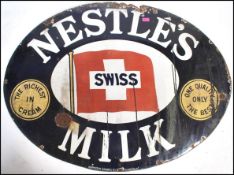 An early 20th century Industrial oval enamel shop advertising sign for ' Nestles Swiss Milk ' The