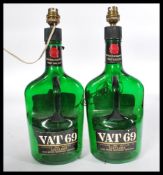 A pair of vintage VAT 69 Whisky bottles having a l