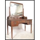 An Edwardian mahogany dressing table being raised