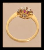 An 18ct gold ruby and diamonds flower head ring of