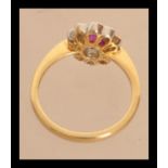 An 18ct gold ruby and diamonds flower head ring of