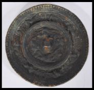 An antique Chinese circular bronze hand mirror of