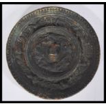 An antique Chinese circular bronze hand mirror of