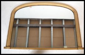 A Victorian gilt wood arched overmantel mirror. Th