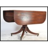 A Regency period solid mahogany drop leaf dining t