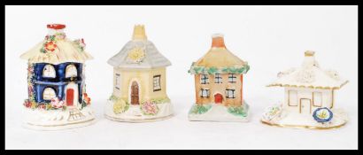A group of four 19th century Staffordshire pastel burners in the form of houses with hand painted