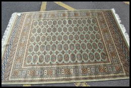 A 20th century Persian Bokhara rug having central multiple medallions raised on green ground with