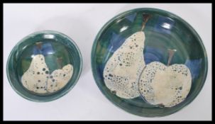 Two pieces of vintage retro 20th century studio art pottery having a green ground with decoration of