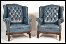 A pair of 20th century leather Chesterfield button back armchairs raised on wooden supports finished