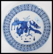 A 19th century Chinese blue and white dinner plate having hand painted decoration of three seated