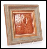 A vintage 20th century brown pottery tile depicting a seated man next to bucket and fence with