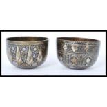 A pair of 19th century Indian bronze prayer bowls having silver overlay decoration of flower heads