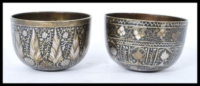 A pair of 19th century Indian bronze prayer bowls having silver overlay decoration of flower heads